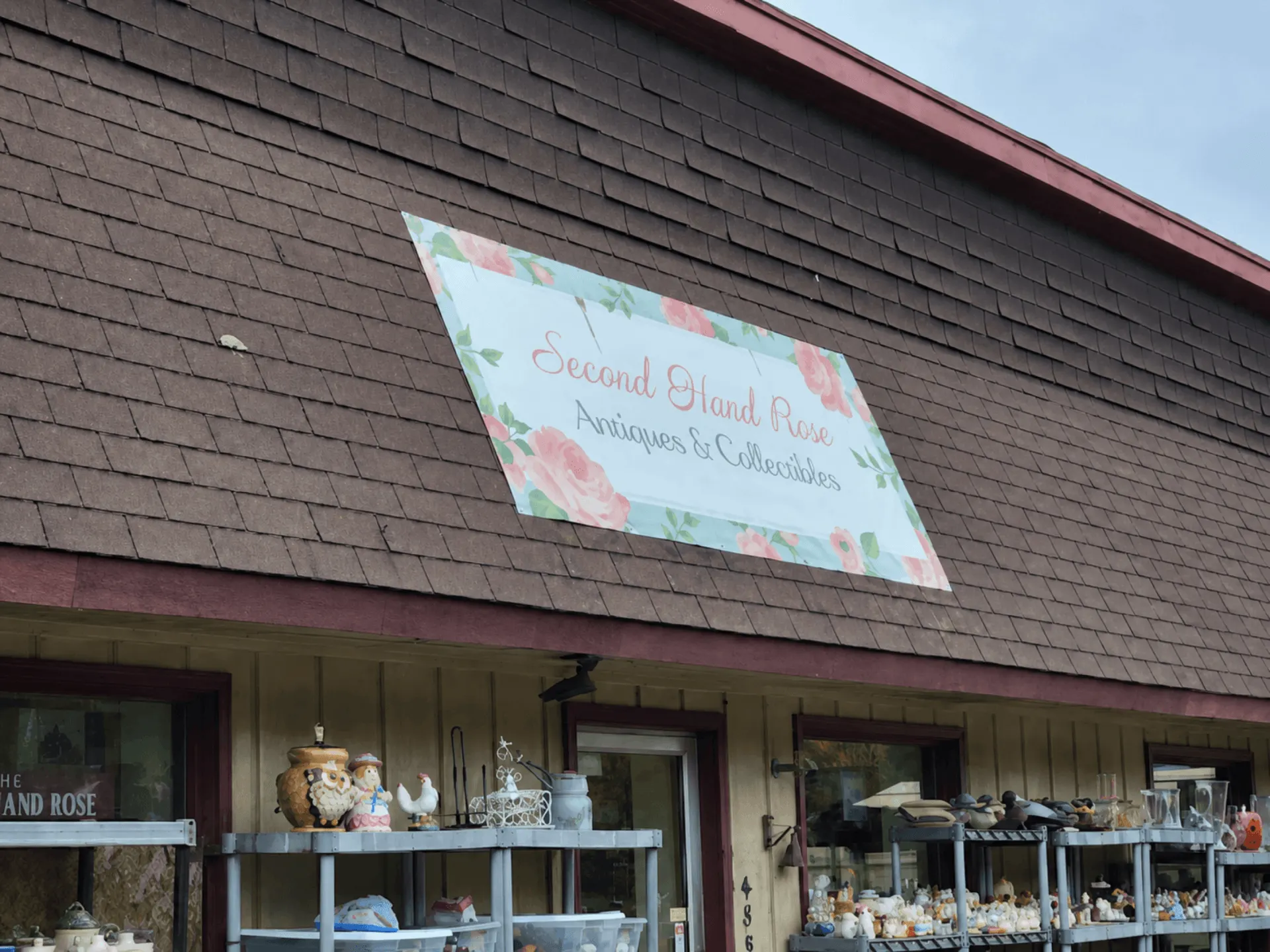 Second Hand Rose Antiques storefront on Highway 61 in Beaver Bay, Minnesota, with the rose sign on the roof and outdoor vintage displays